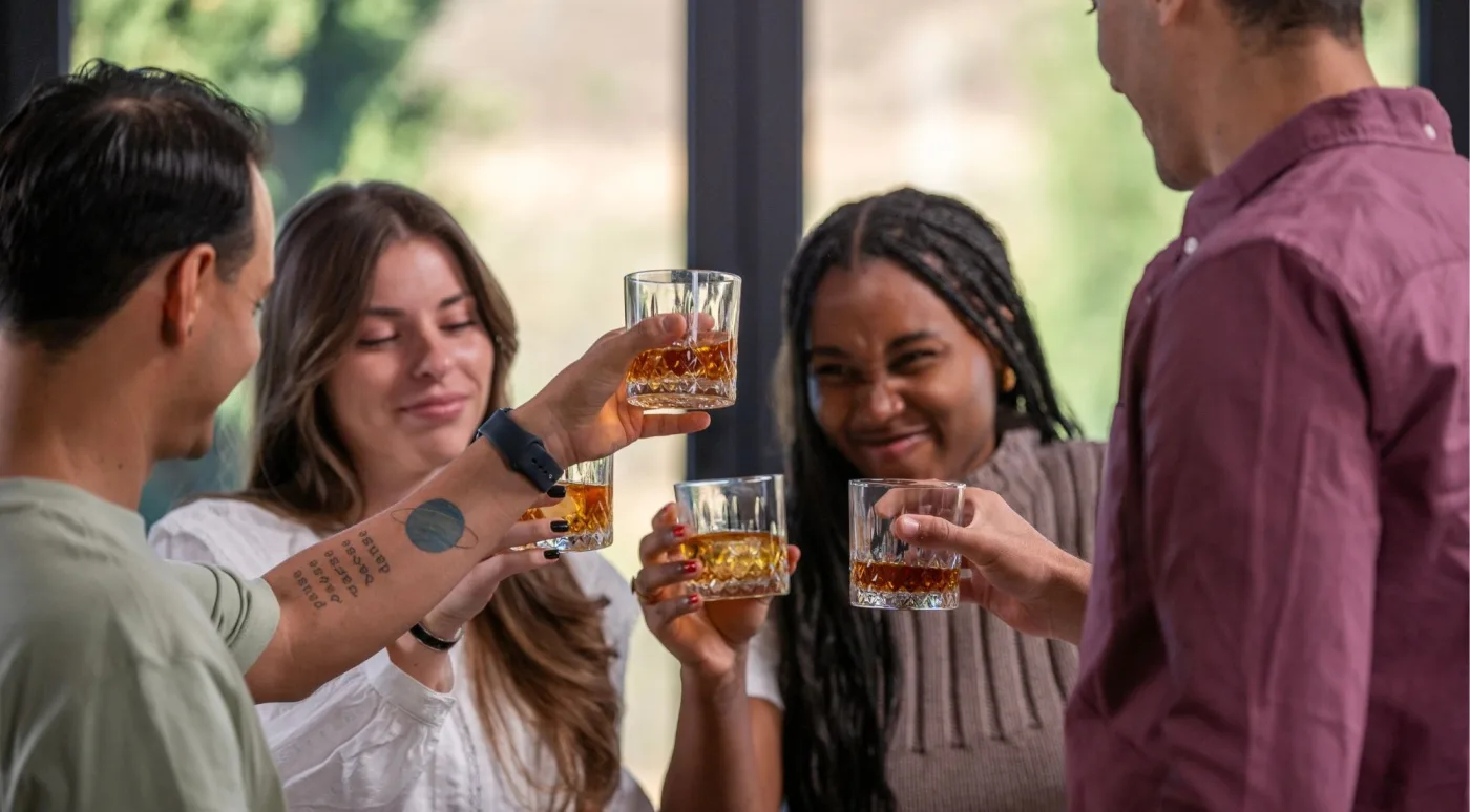 A group of friends toasting with whiskey glasses during a Dublin tasting