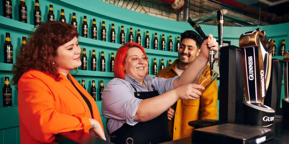 A visitor learning to pull a perfect pint at the Guinness Academy