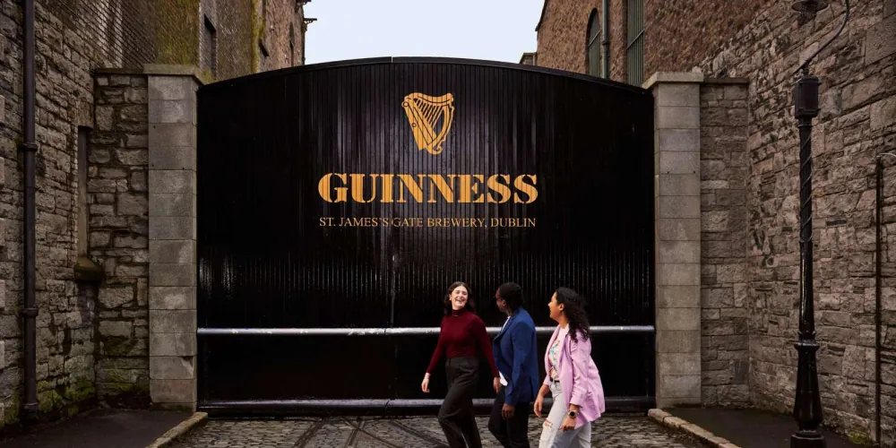 Visitors at the black Guinness gate of St James's Gate Brewery, Dublin